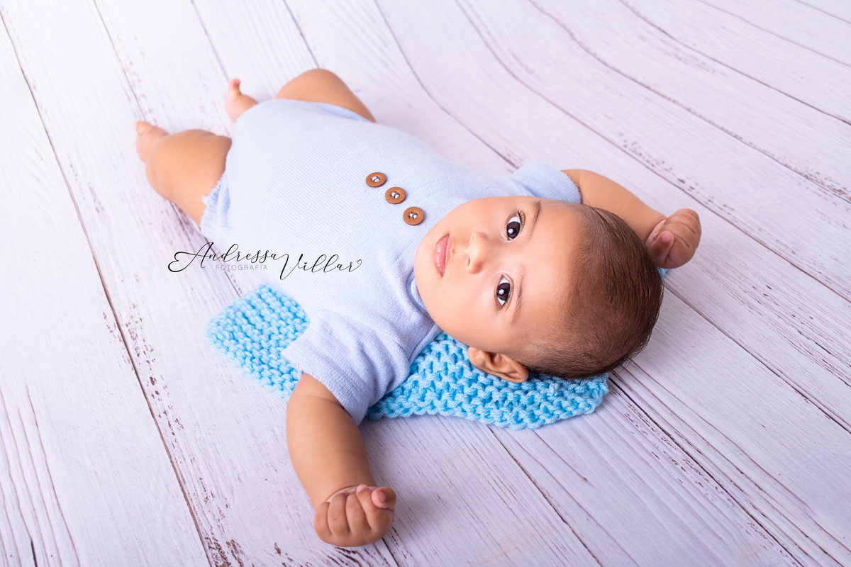 Gustavo de barriga para cima olhando para foto tirada de costas