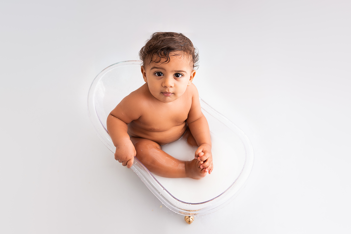 bebê na banheira tomando banho de leite 