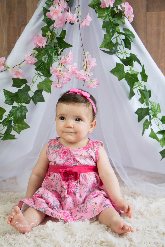 De vestido florido e laço na cabeça, a pequena princesa com seu sorriso angelical!