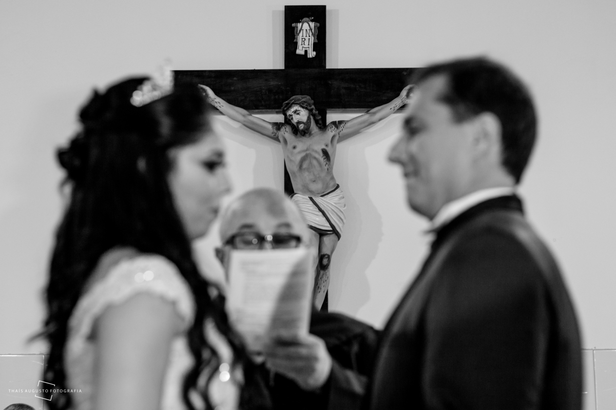 cruz em meio ao casal na celebração de casamento na paróquia santo antonio em agudos-sp