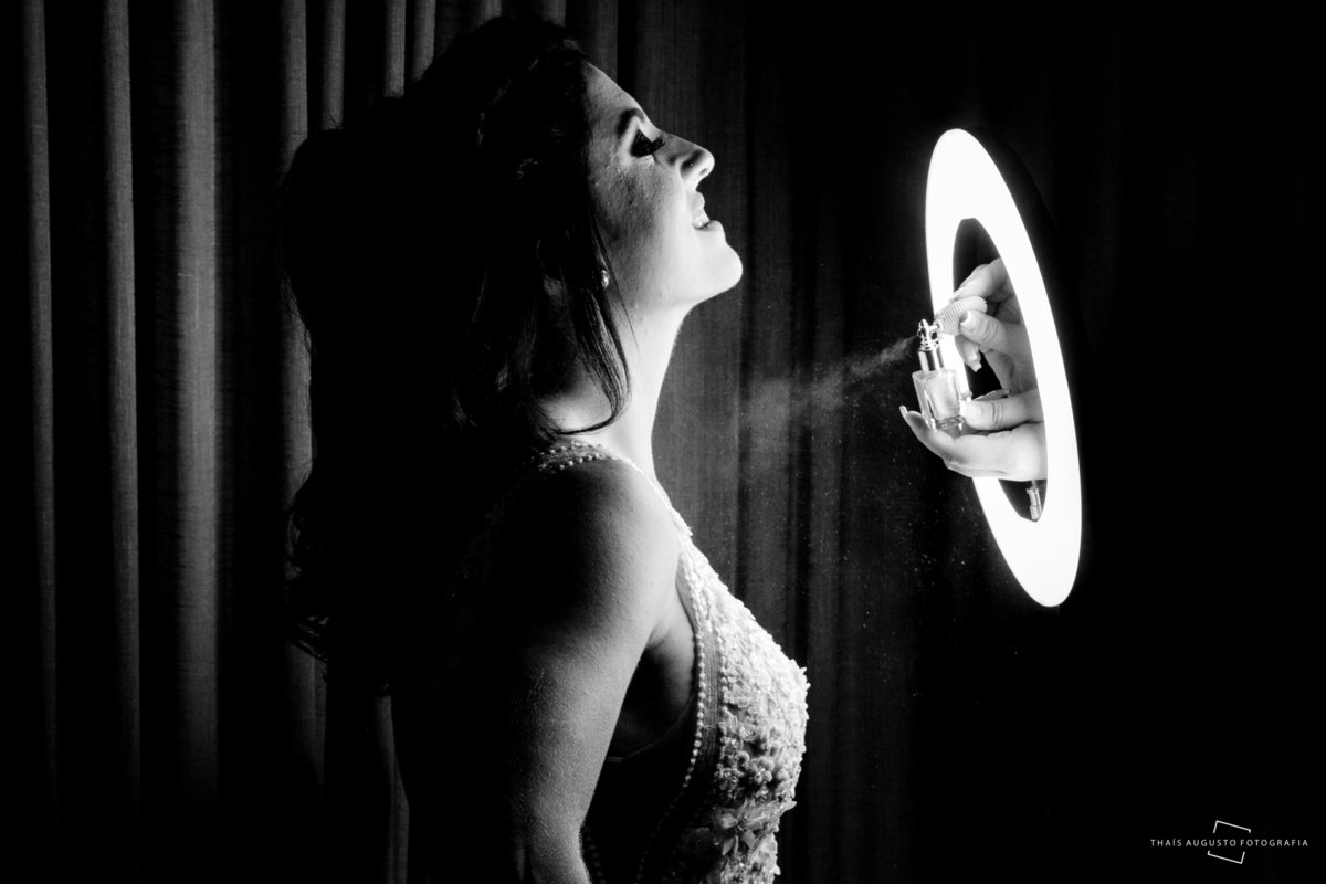 maquiadora finalizando a noiva no making of com brilho no ring light