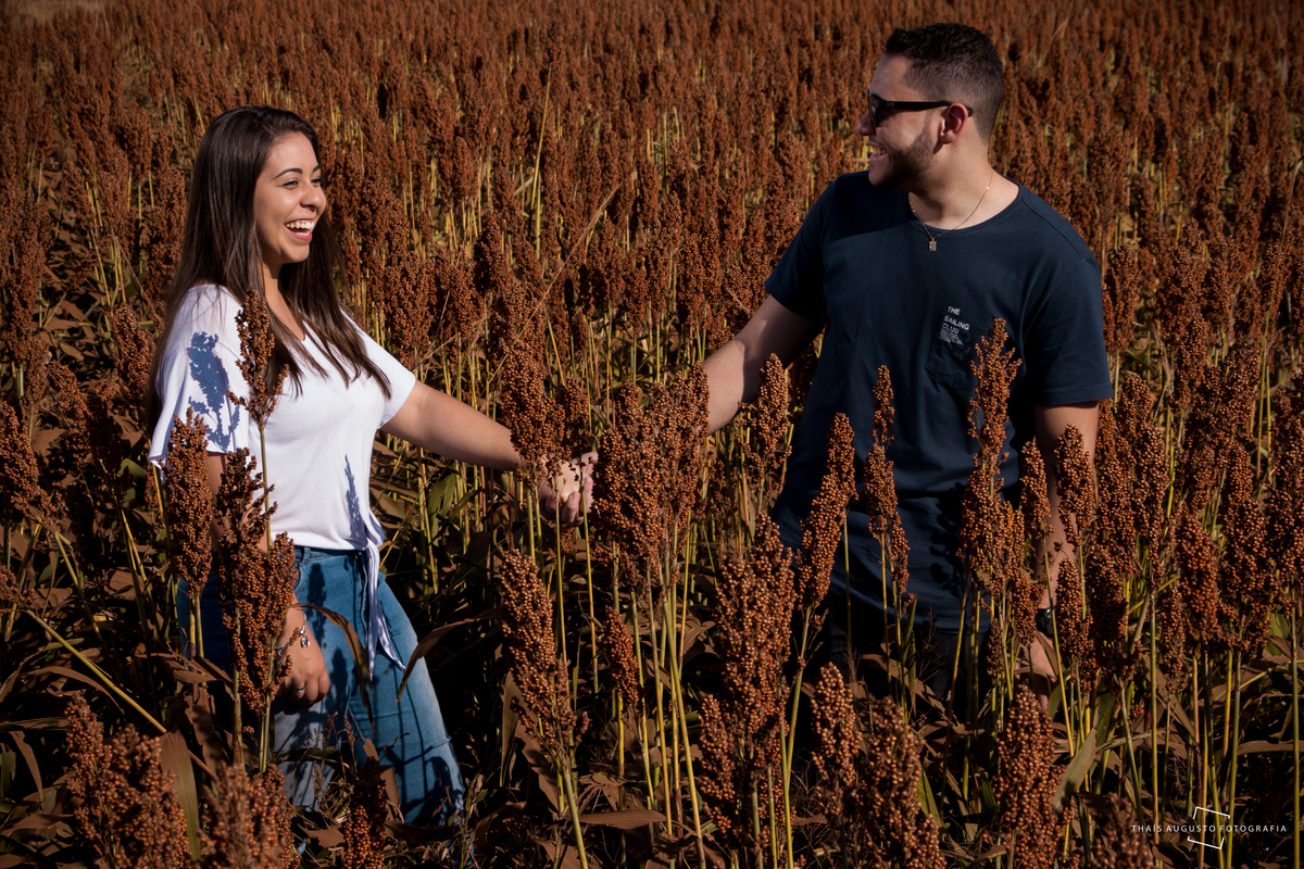 sorriso, casal correndo no campo de flores é fotografado pela Thais Augusto fotógrafa de casamento na cidade de BauruSP