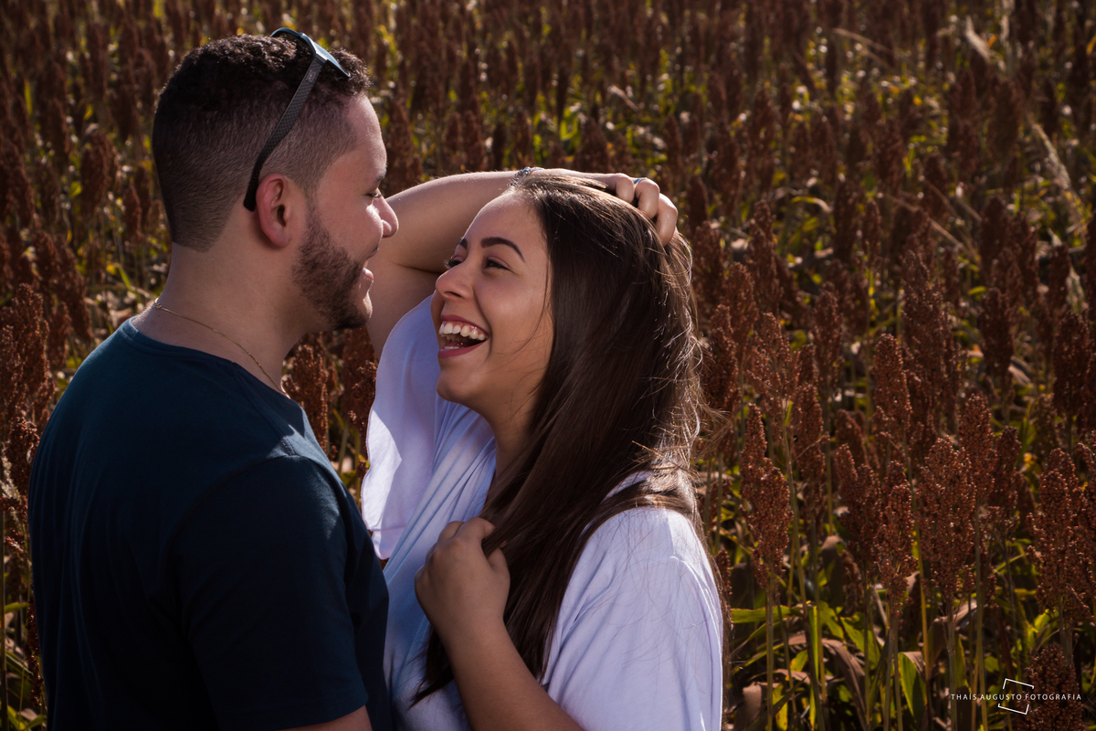sorriso, espontaneidade de casal de noivos, namorados em campo de flores, ensaio realizado pela fotógrafa de casamento Thais Augusto Fotografia 