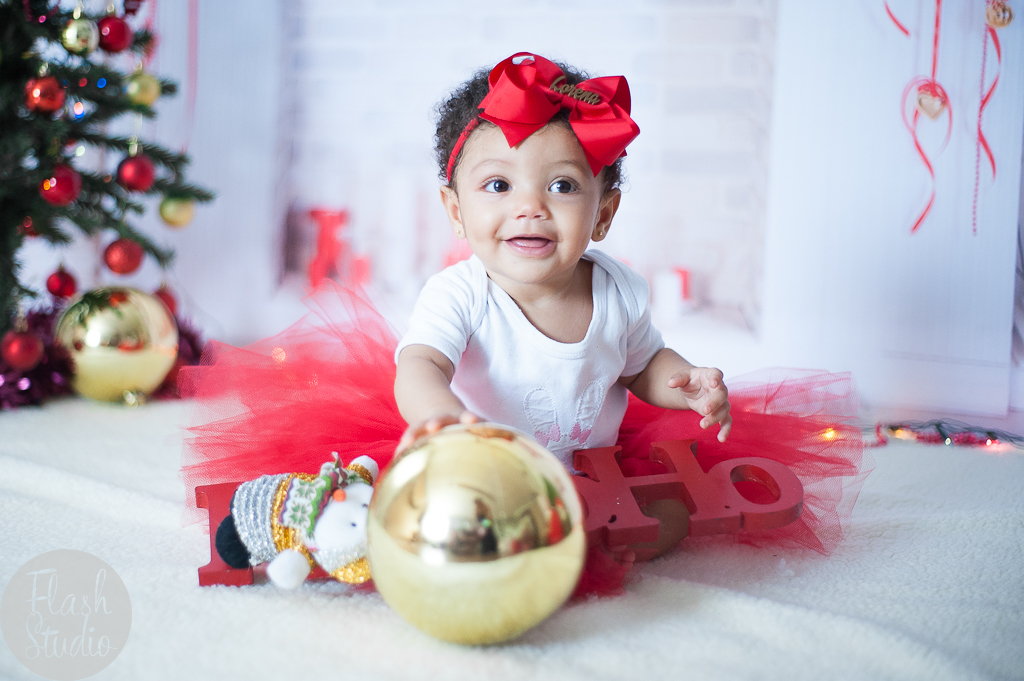 foto de bebe sorridente com bola de natal e ensaio natalino no rio de janeiro