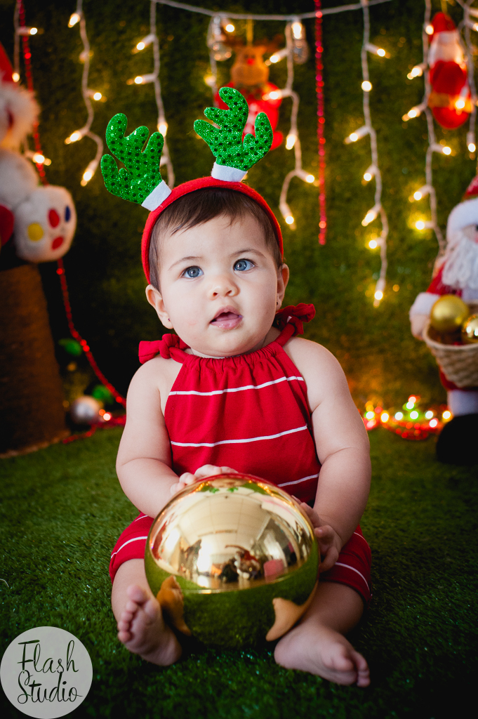 bebe com bolinha de natal em cenario de natal, em ensaio de natal em bangu no rio de Janeiro