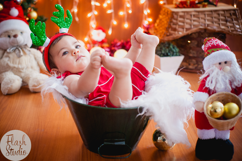 bebe segurando os pes em cenario de natal, em ensaio de natal em bangu no rio de Janeiro