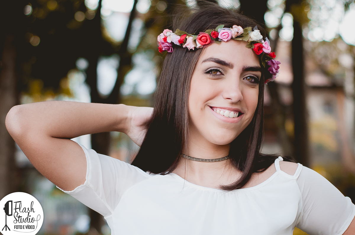mulher com flores na cabeça, sorri em um ensaio externo feito no rio de janeiro