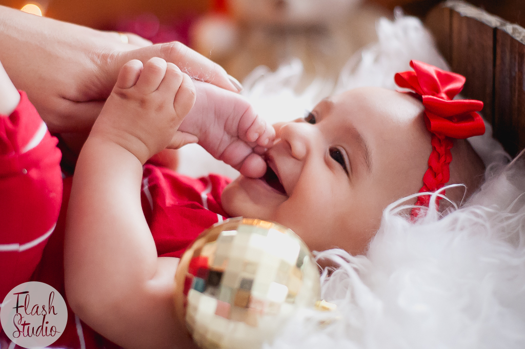 bebe mordendo pé com bolinha de natal, em book de natal em bangu no rio de janeiro