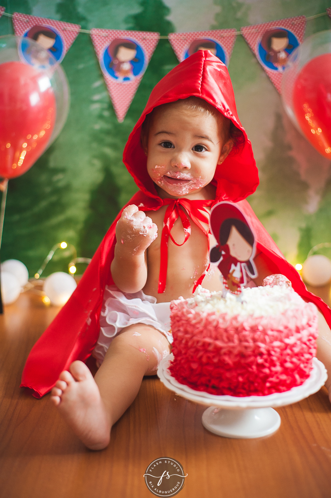 bebe esmagando o bolo  em  smash the cake da chapeuzinho vermelho em estudio, em bangu no rio de janeiro