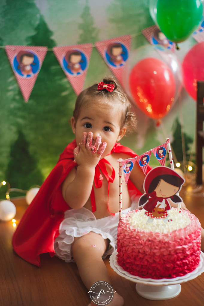 bebe comendo bolo  em  smash the cake da chapeuzinho vermelho em estudio, em bangu no rio de janeiro