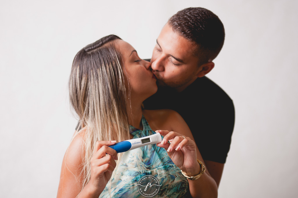 casal se beijando com teste de gravidez em ensaio de gestante em estudio, em bangu no rio de janeiro 
