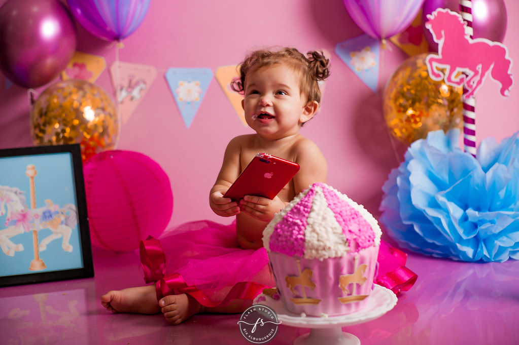 bebe brincando com celular em cake smash/ smash the cake de carrossel, no rio de janeiro, em bangu