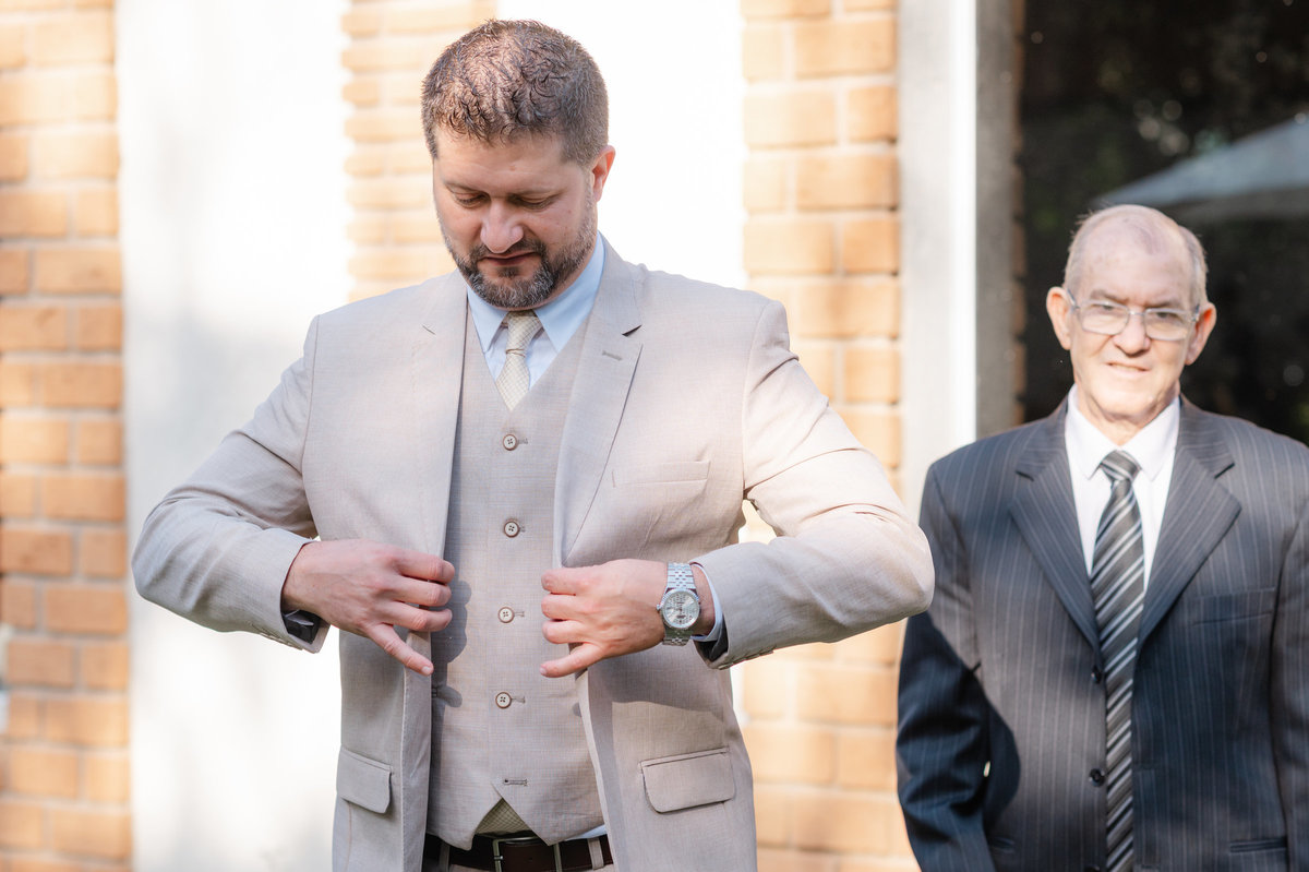 Juliano se prepara para a cerimônia de casamento acompanhado de um familiar, em um momento especial antes da celebração.