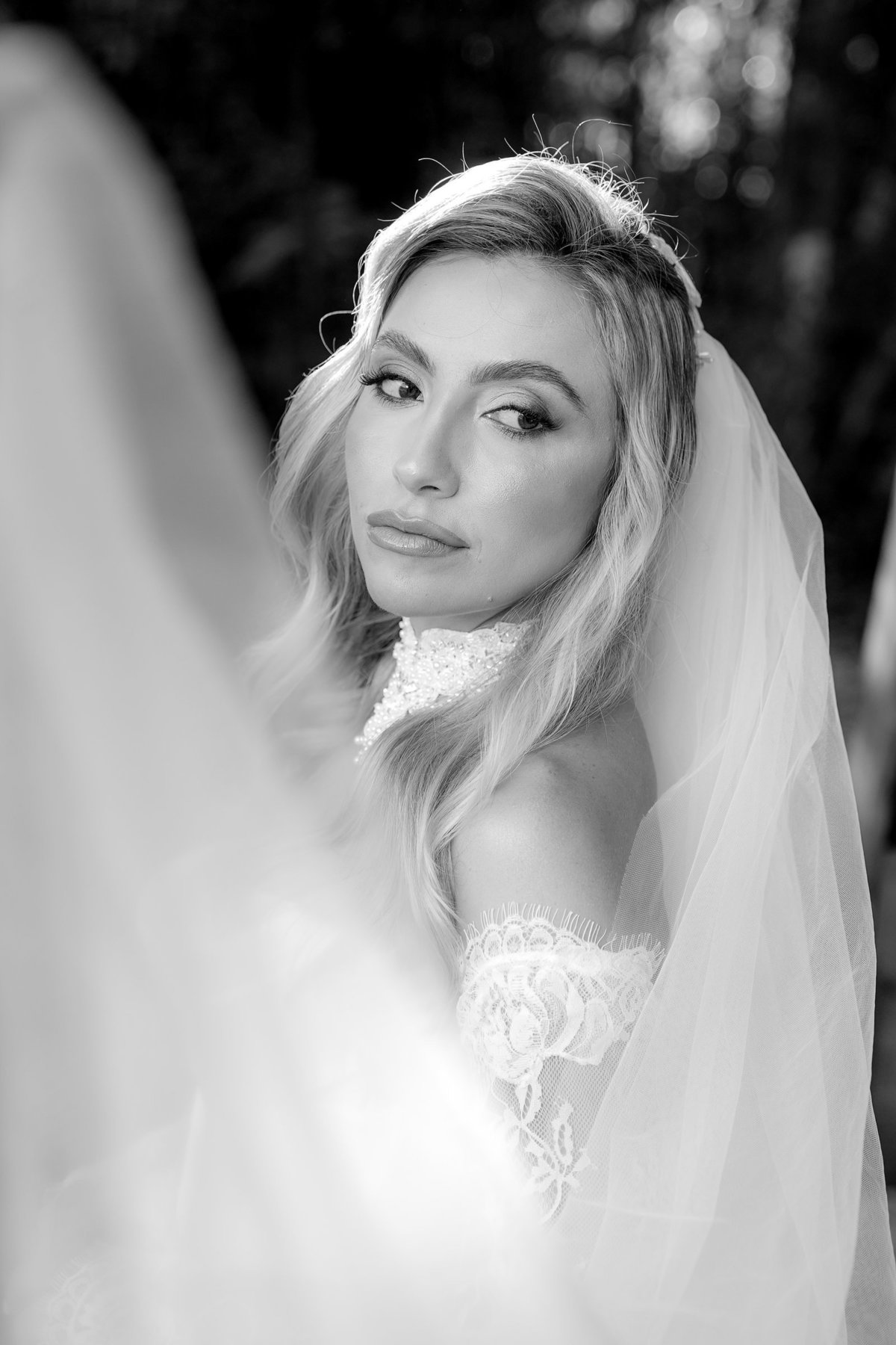 Retrato em preto e branco da noiva Ana Rute usando o véu, destacando sua expressão e a delicadeza dos preparativos para o casamento no Sítio Santa Paula, em Pouso Alegre.