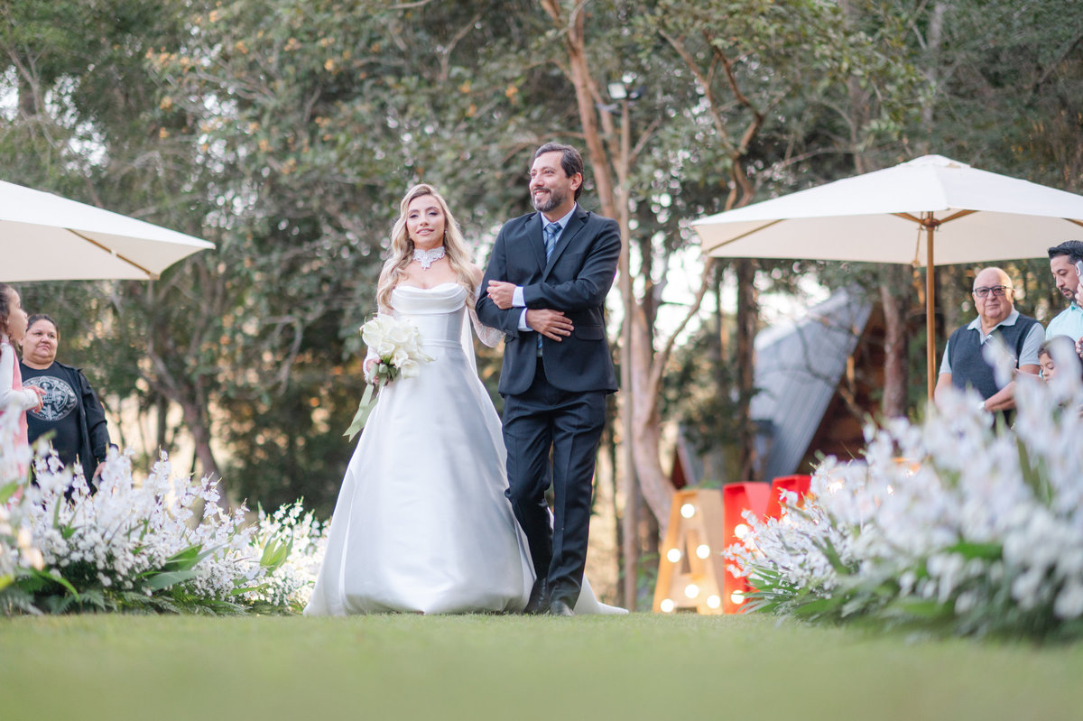 Ana Rute entra na cerimônia acompanhada, em um dos momentos mais emocionantes do casamento no Sítio Santa Paula.