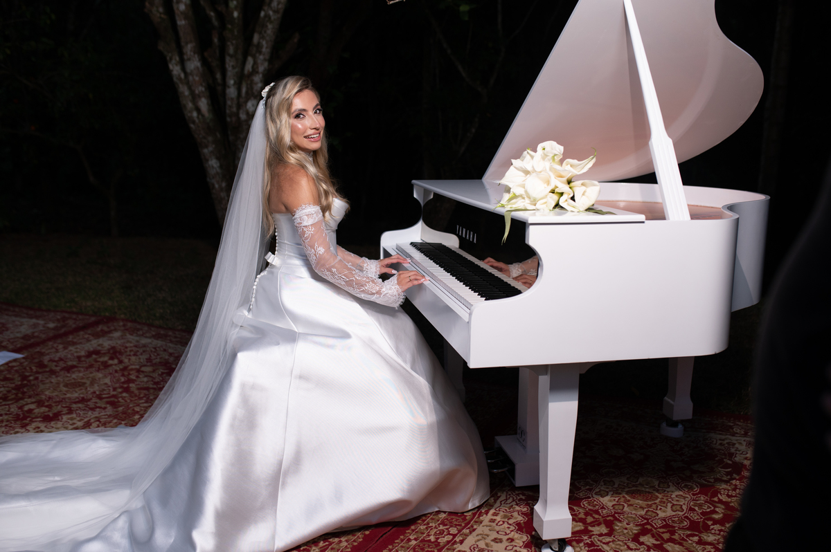 Retrato artístico de Ana Rute junto ao piano branco, valorizando o vestido e a atmosfera da fotografia.