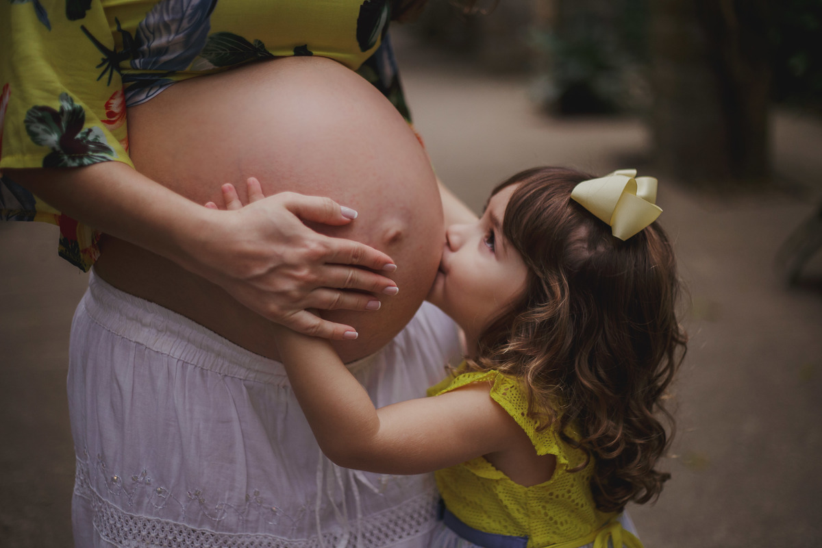 filha beijando a barriga da mãe