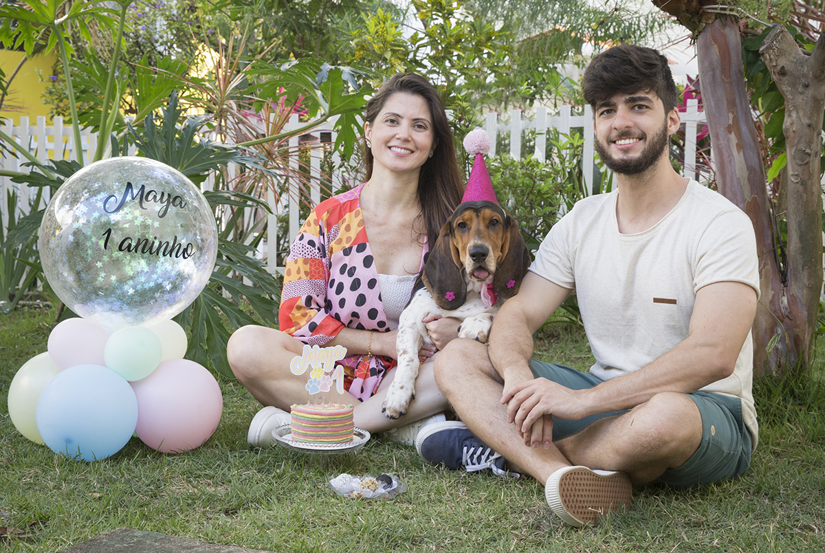 Basset Hound posando com a familia e a decoracao de aniversario