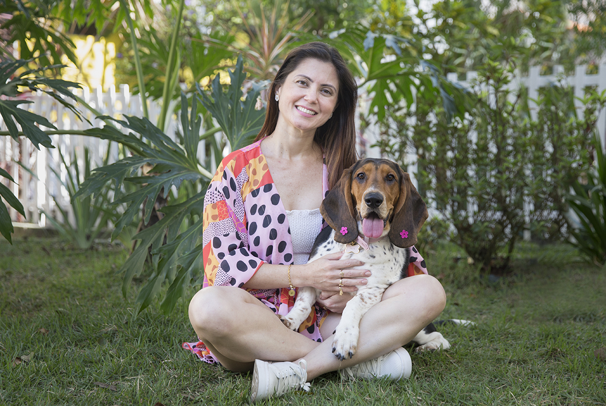 Basset Hound olhando para camera, abraçada com a tutora