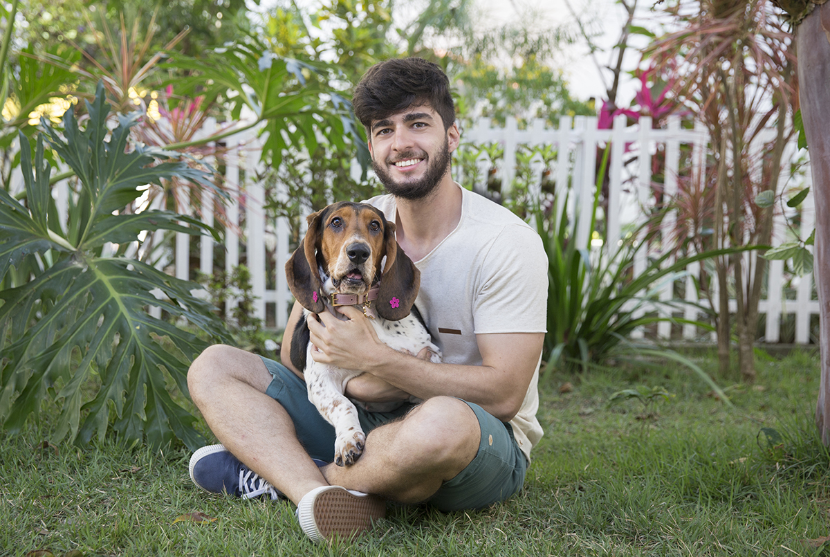 Basset Hound olhando para camera, abraçada com o tutor