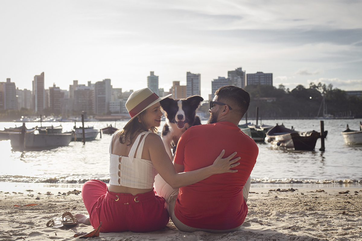 Luck com seus pais, na areia da praia com os barcos ao fundo