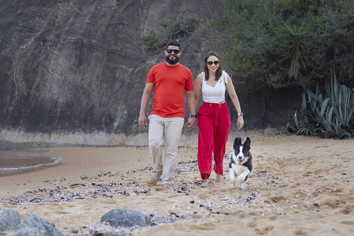 Luck corre com seus pais, na areia da praia em meio as conchinhas