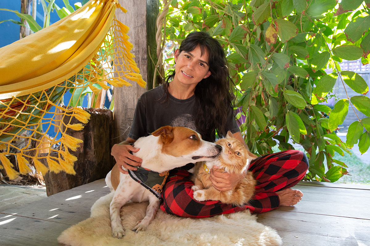 Tião no colo da mamãe, dando um beijo no irmão gato