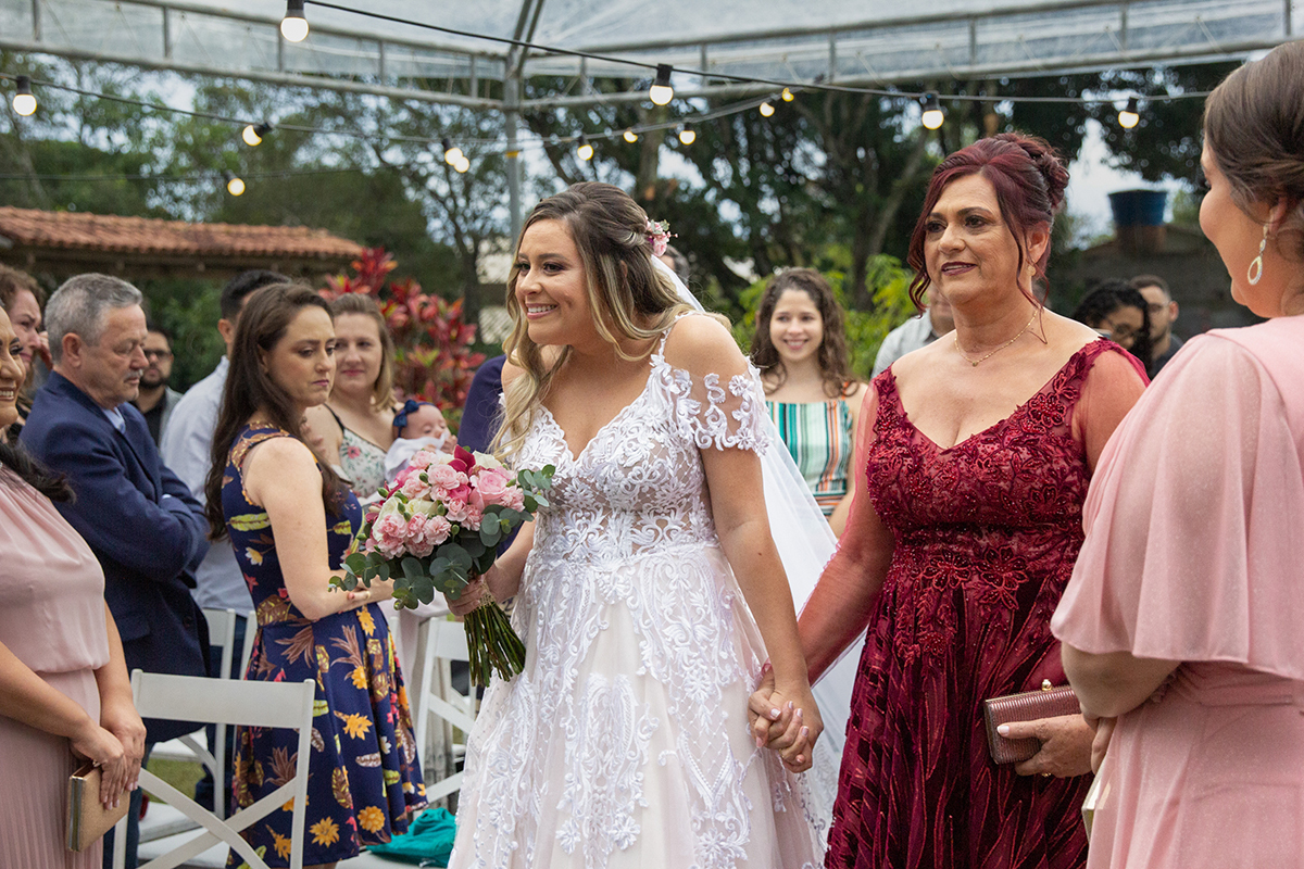 entrada da noiva, sorridente com sua mãe