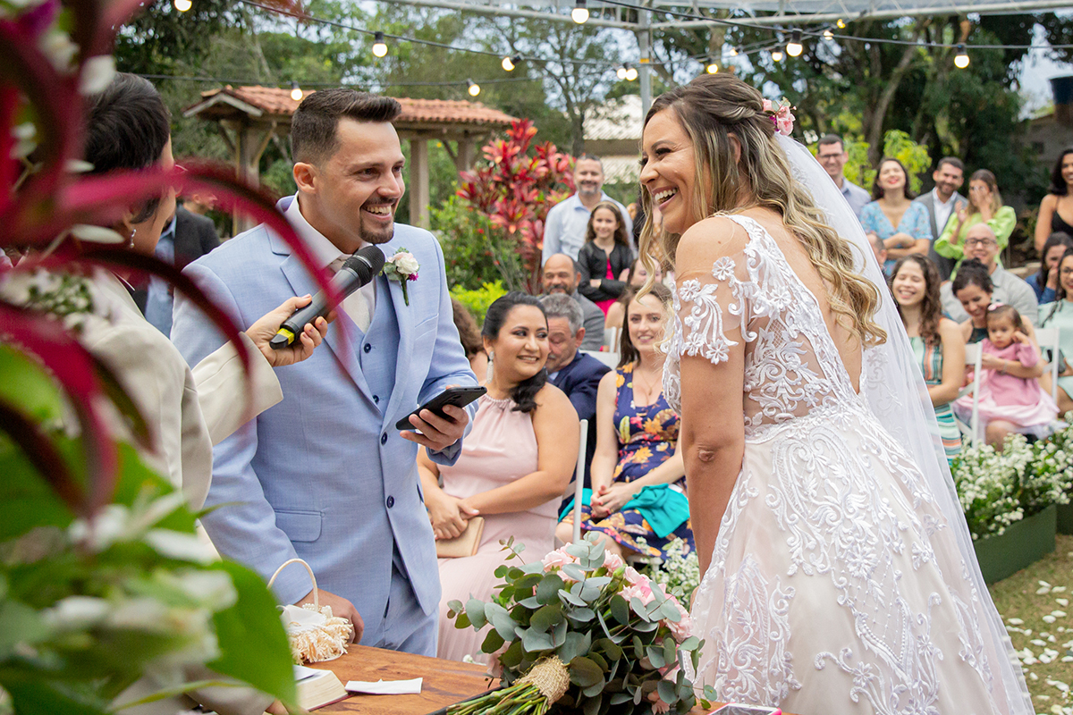 Noivo fqz seus votos no altar, ambos sorriem