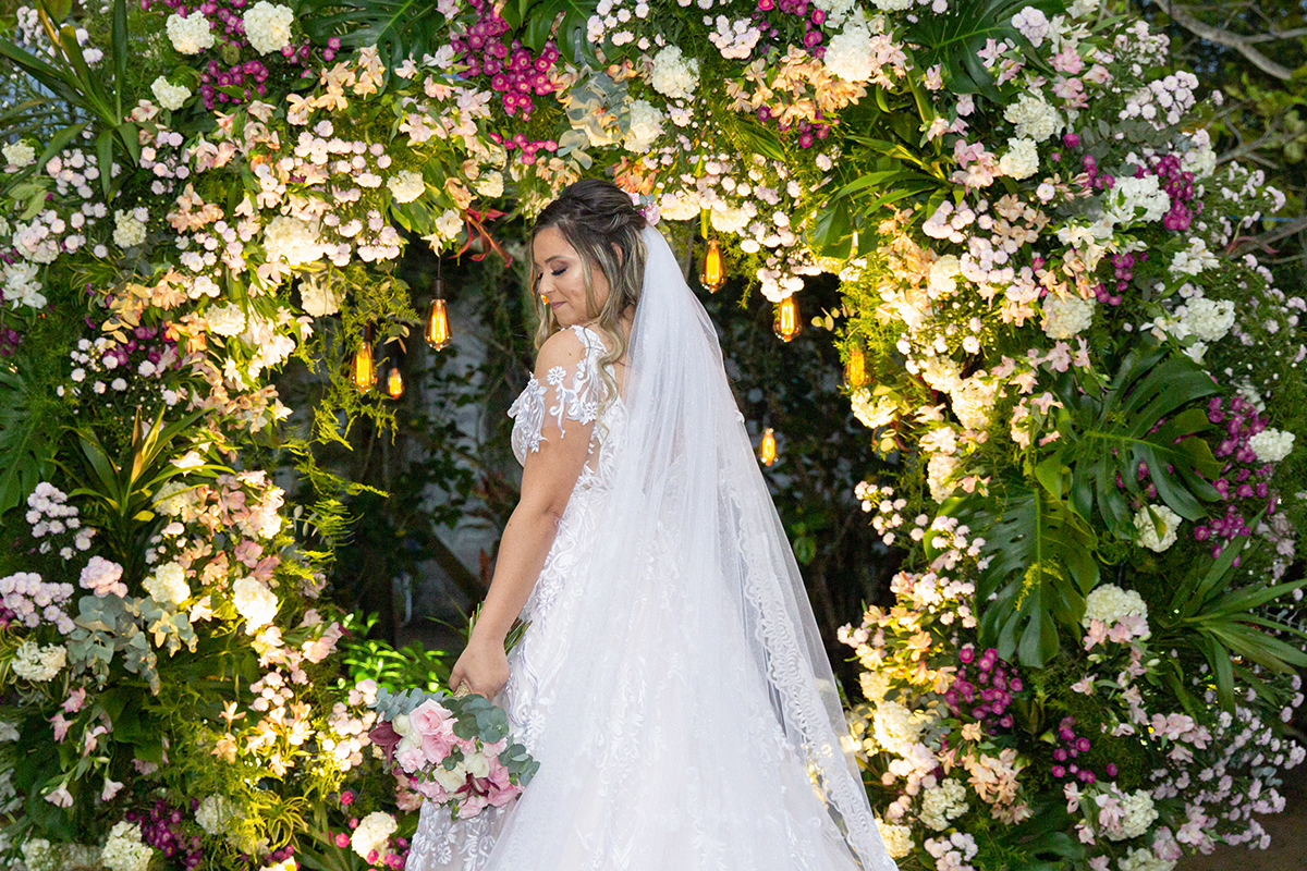 Retrato da  noiva no arco de flores