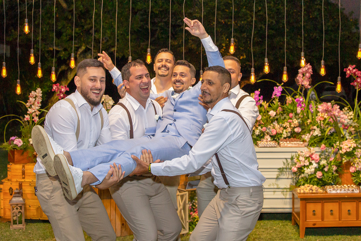 padrinhos jogam o noivo para cima