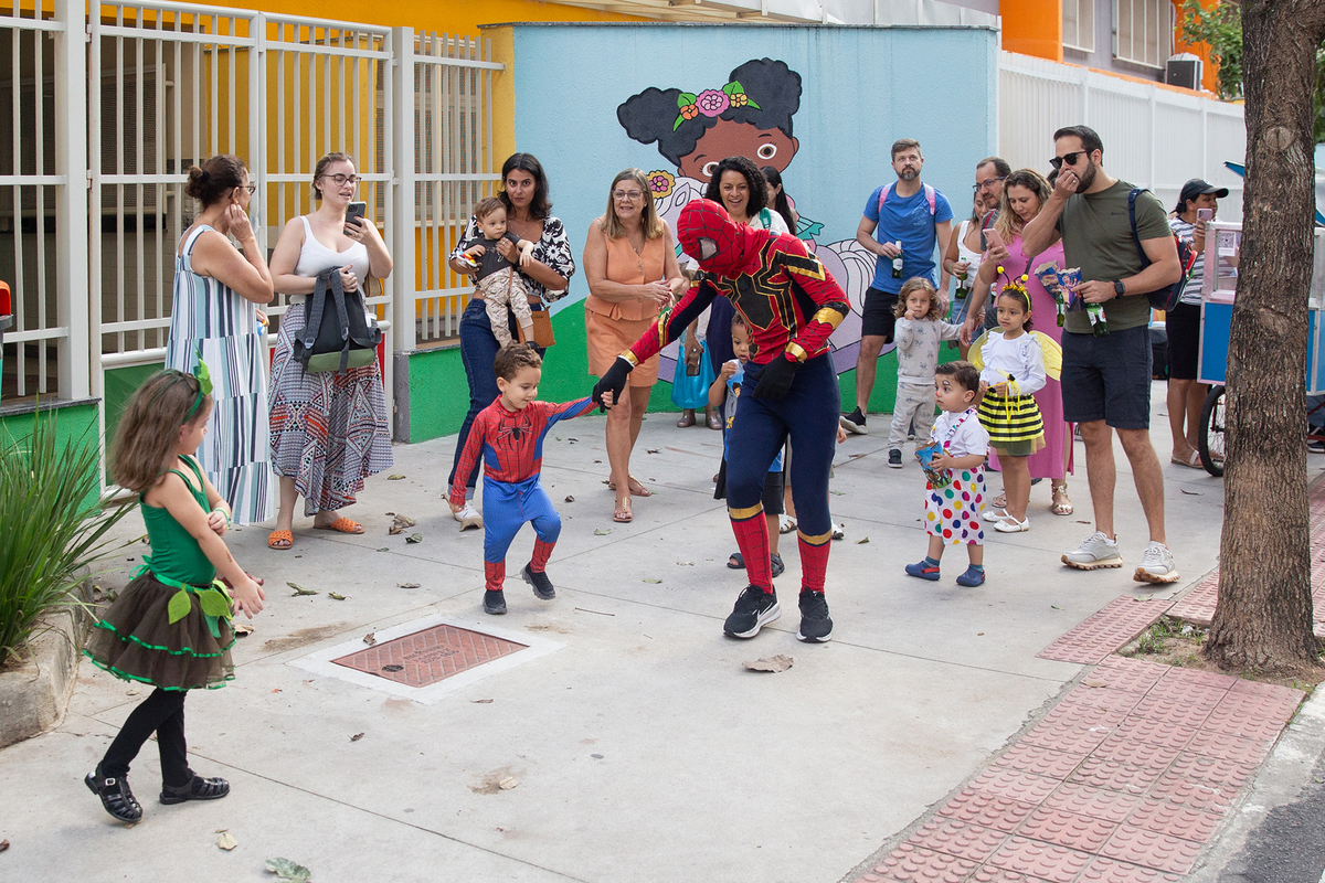 aniversariante comemorando 3 anos vestido de Homem-Aranha durante sua festa no Carretão da Alegria, dançando na calçada