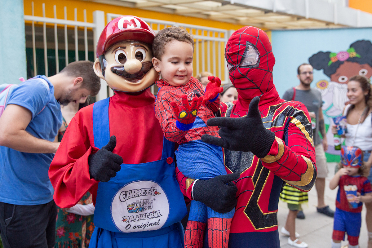aniversariante comemorando 3 anos vestido de Homem-Aranha durante sua festa no Carretão da Alegria, posando com Mario Bros e Homem aranha