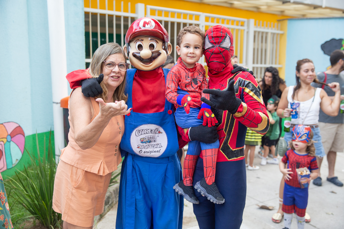 aniversariante comemorando 3 anos vestido de Homem-Aranha durante sua festa no Carretão da Alegria, posando com Mario Bros e Homem aranha e vovó