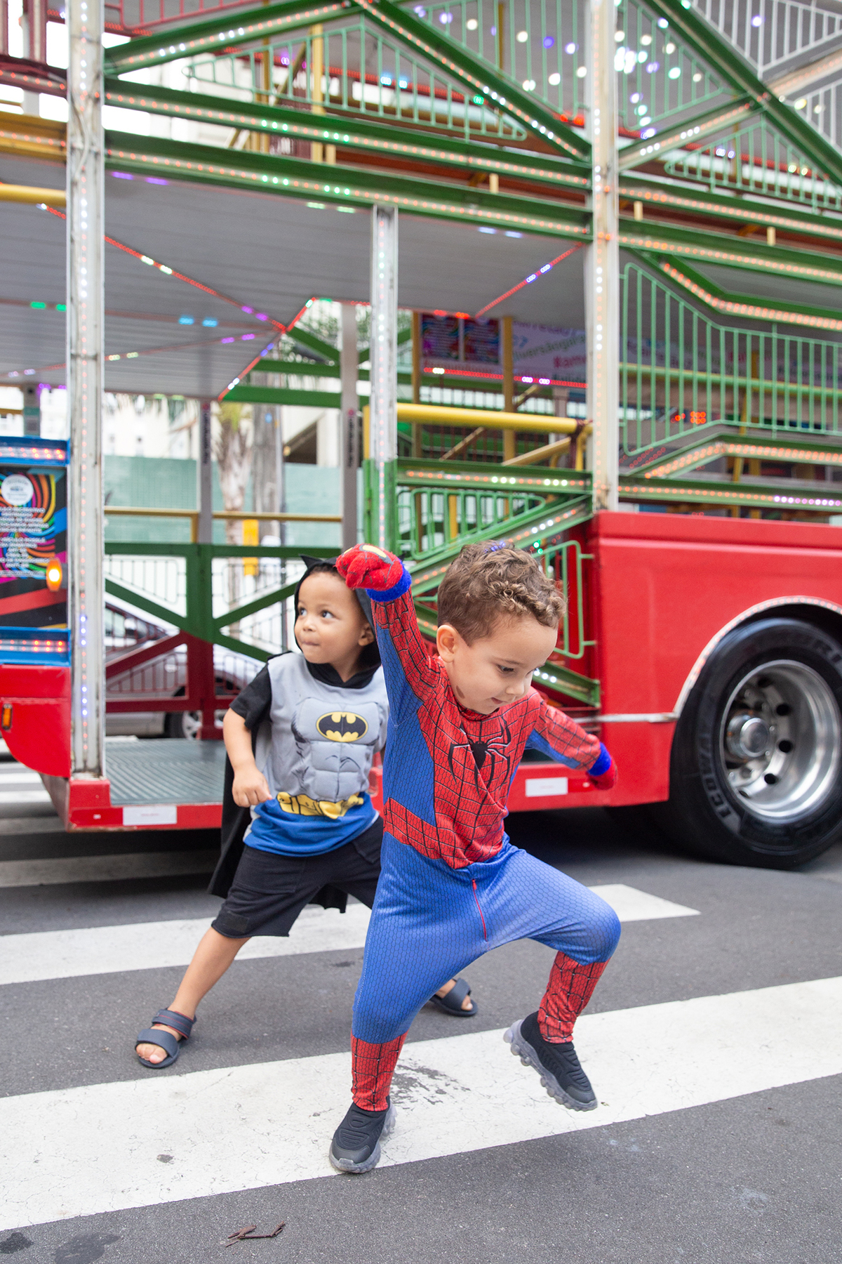 aniversariante comemorando 3 anos vestido de Homem-Aranha durante sua festa no Carretão da Alegria, dançando na calçada