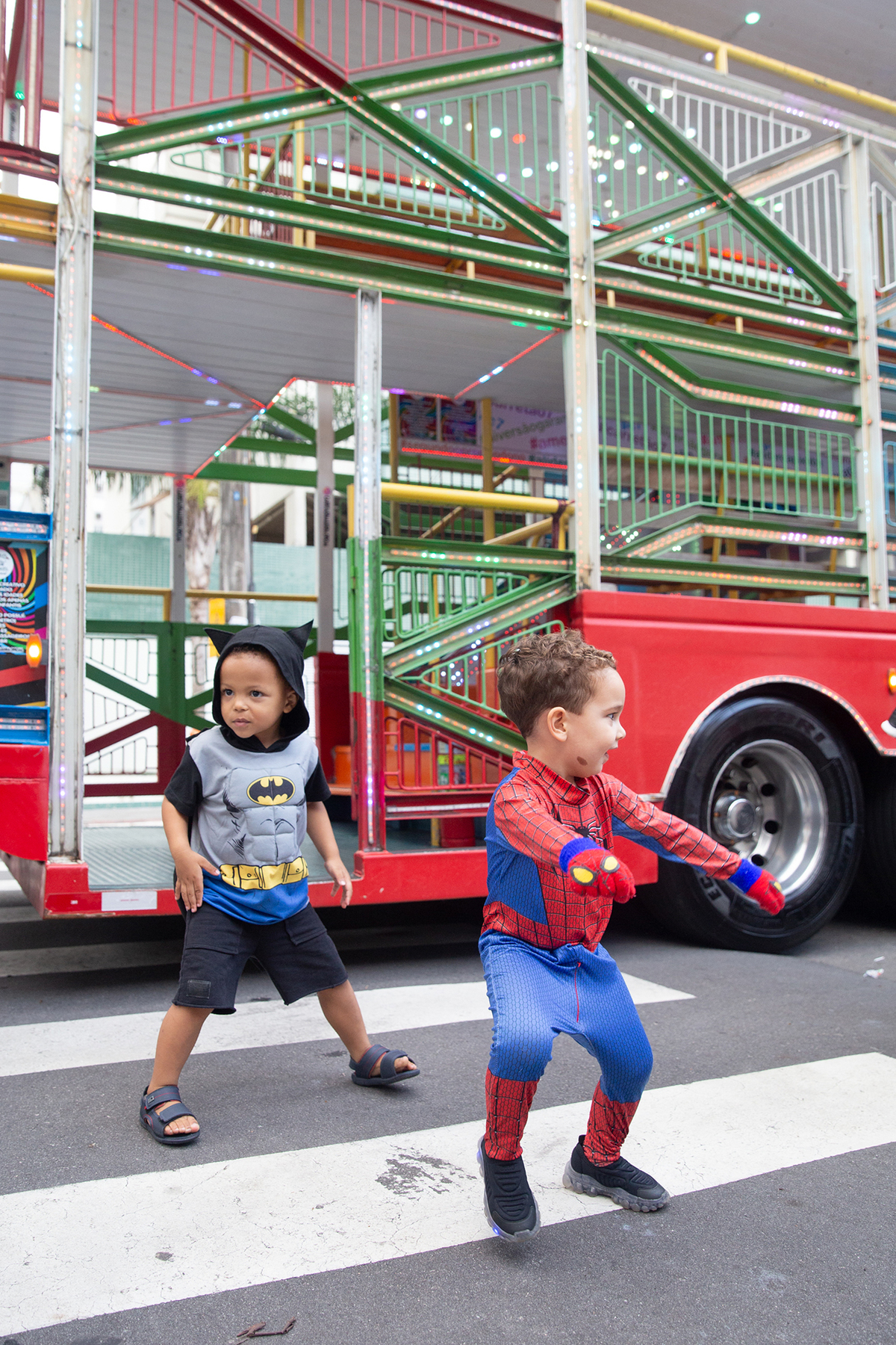 aniversariante comemorando 3 anos vestido de Homem-Aranha durante sua festa no Carretão da Alegria, dançando na calçada