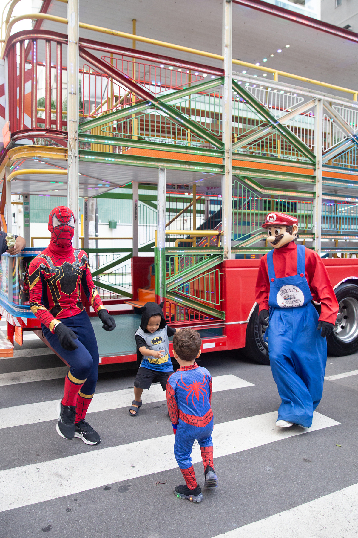 aniversariante comemorando 3 anos vestido de Homem-Aranha durante sua festa no Carretão da Alegria, dançando na calçada