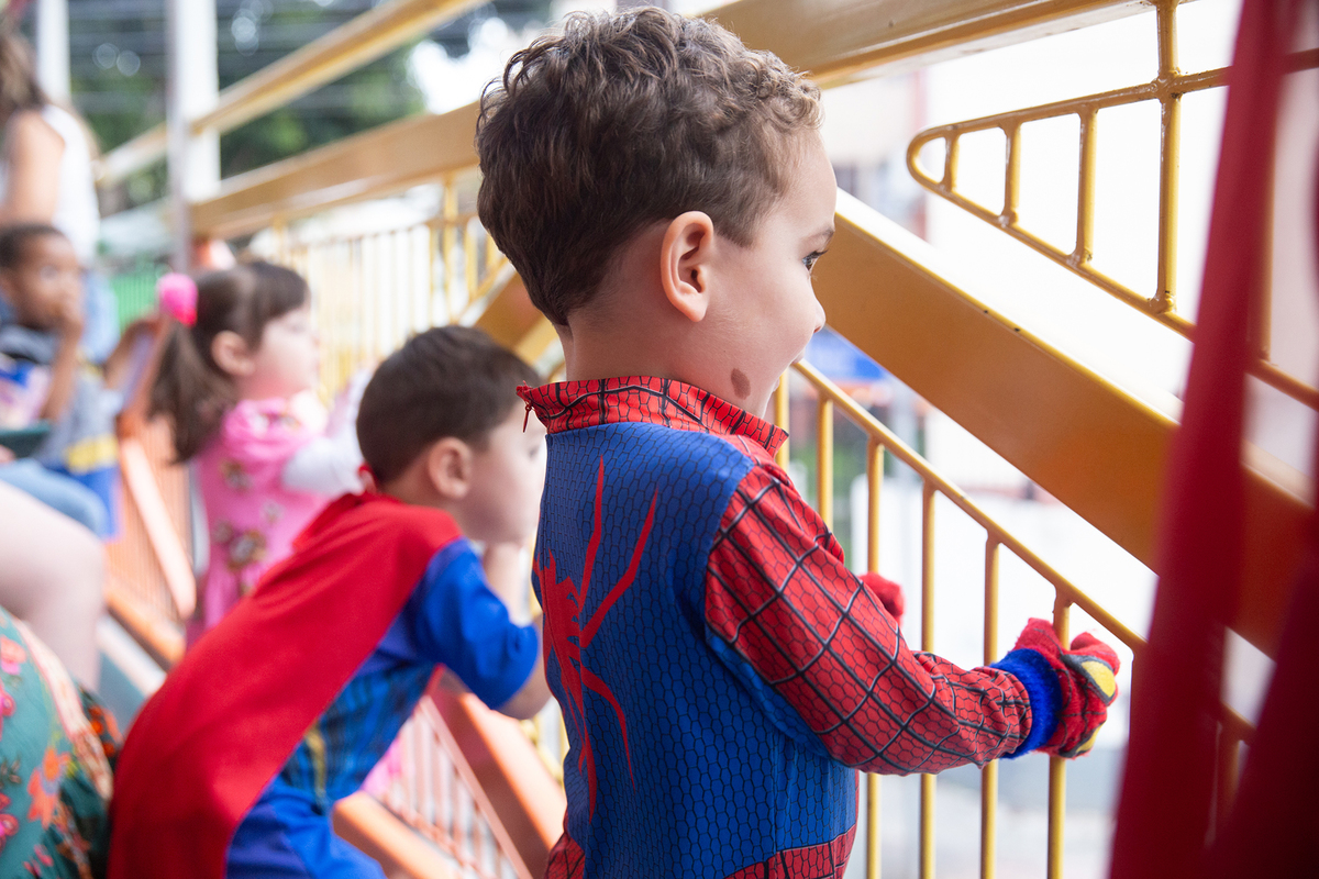 aniversariante comemorando 3 anos vestido de Homem-Aranha durante sua festa no Carretão da Alegria, dançando na carreta com os amigos
