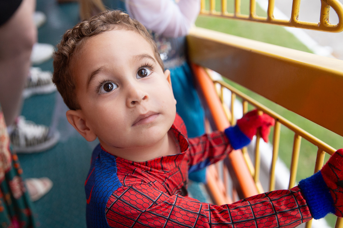 aniversariante comemorando 3 anos vestido de Homem-Aranha durante sua festa no Carretão da Alegria, dançando na carreta com os amigos