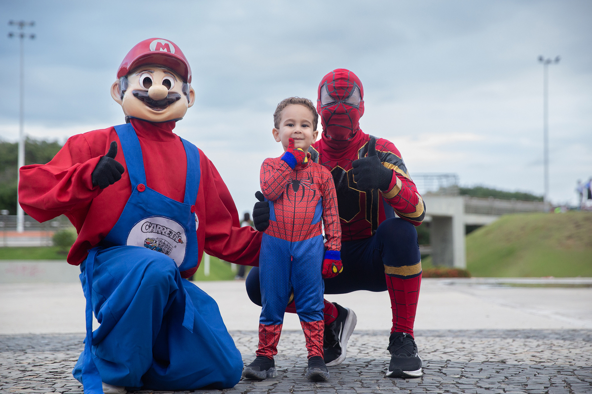 aniversariante posando com homem-aranha e mario bros, no calçadão de jardim camburi