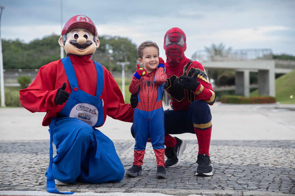 aniversariante posando com homem-aranha e mario bros, no calçadão de jardim camburi