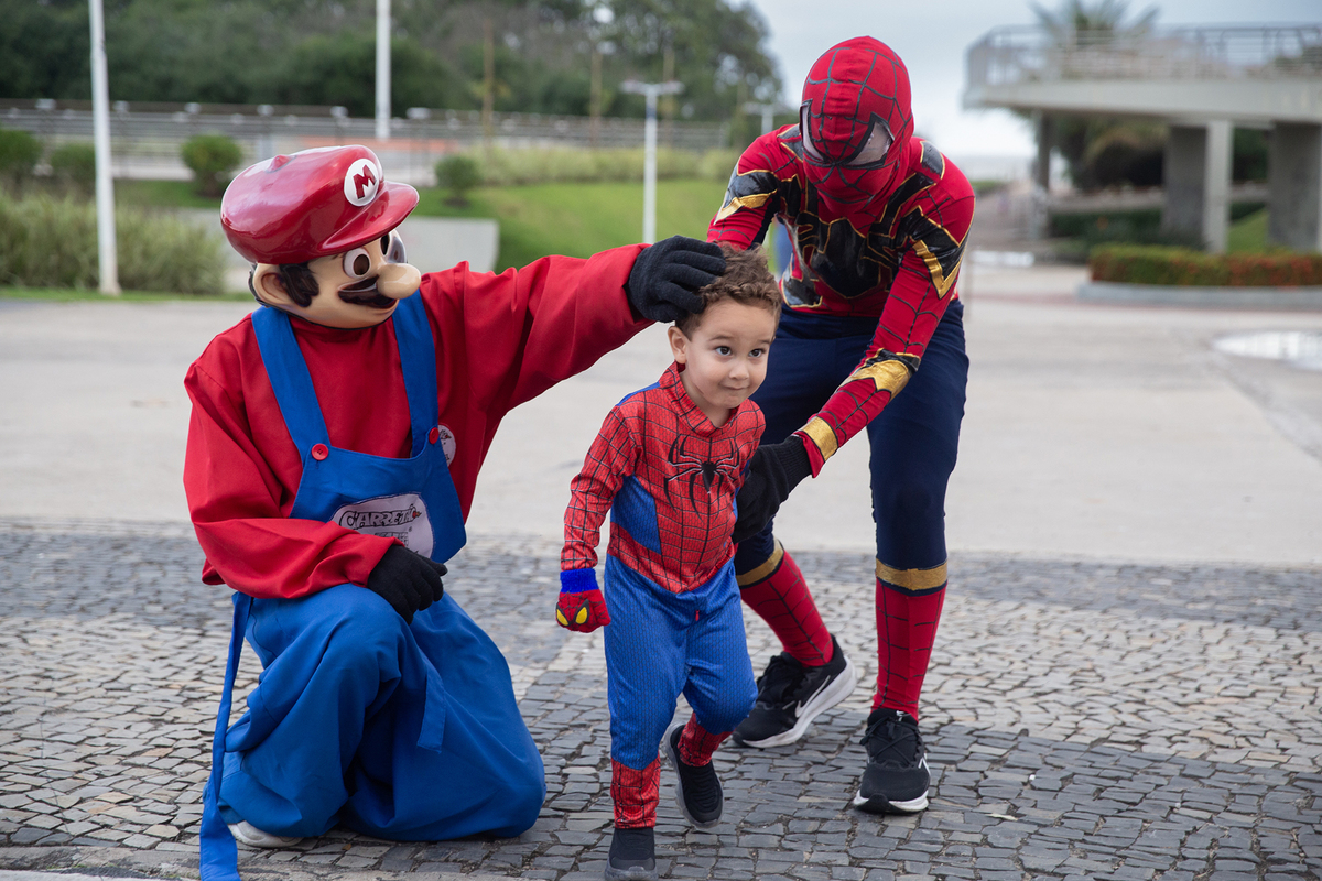 aniversariante posando com homem-aranha e mario bros, no calçadão de jardim camburi