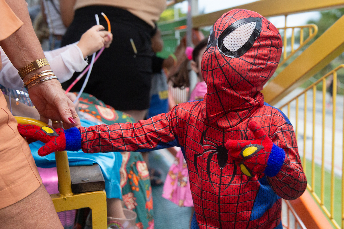 aniversariante comemorando 3 anos vestido de Homem-Aranha durante sua festa no Carretão da Alegria, dançando na carreta com os amigos