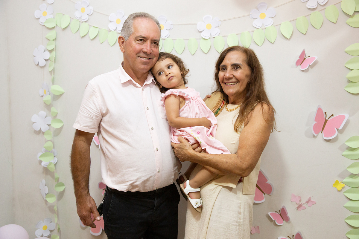 Vovó e vovô dando beijo na aniversariante, na mesa do bolo, em aniversario intimista