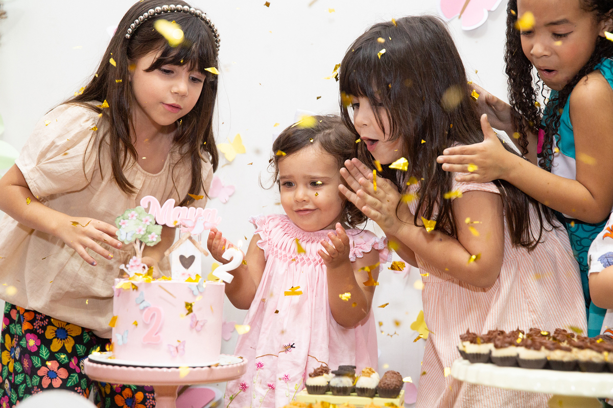 crianças na mesa do bolo comemorando os dois anos da aniversariante na hora do parabéns 