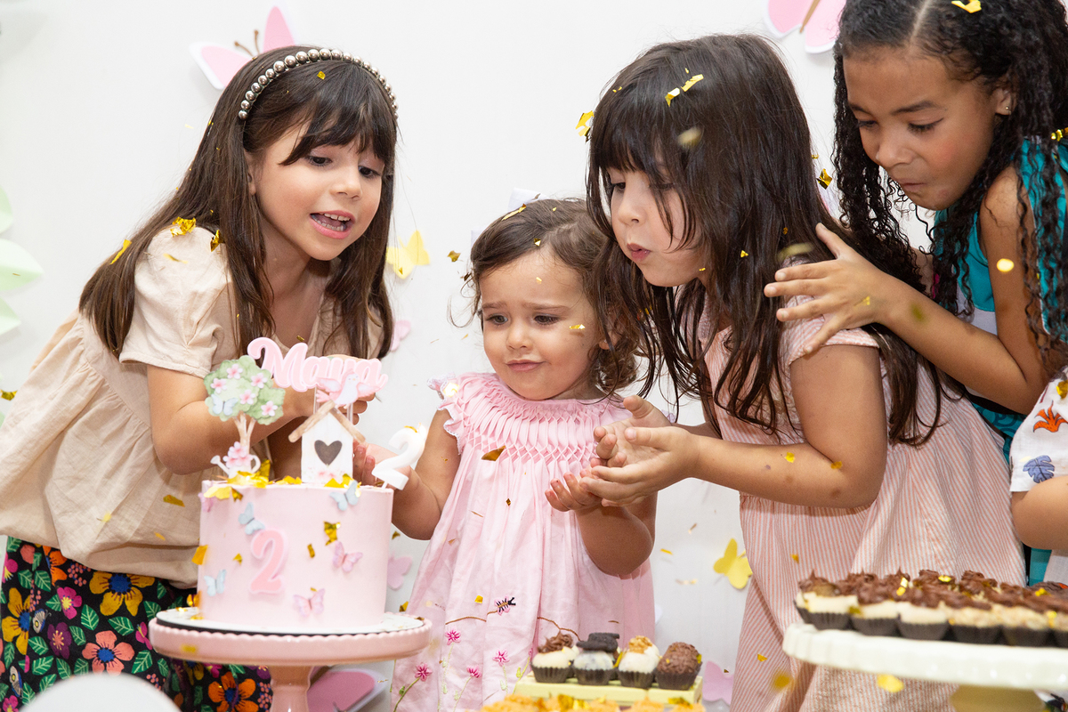 crianças na mesa do bolo comemorando os dois anos da aniversariante na hora do parabéns 