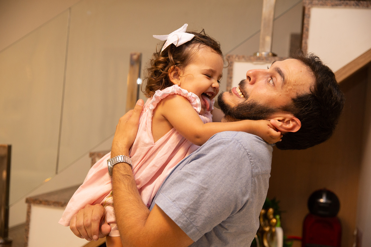 Momento de brincadeira entre crianças pai e filha em festa de aniversario em casa