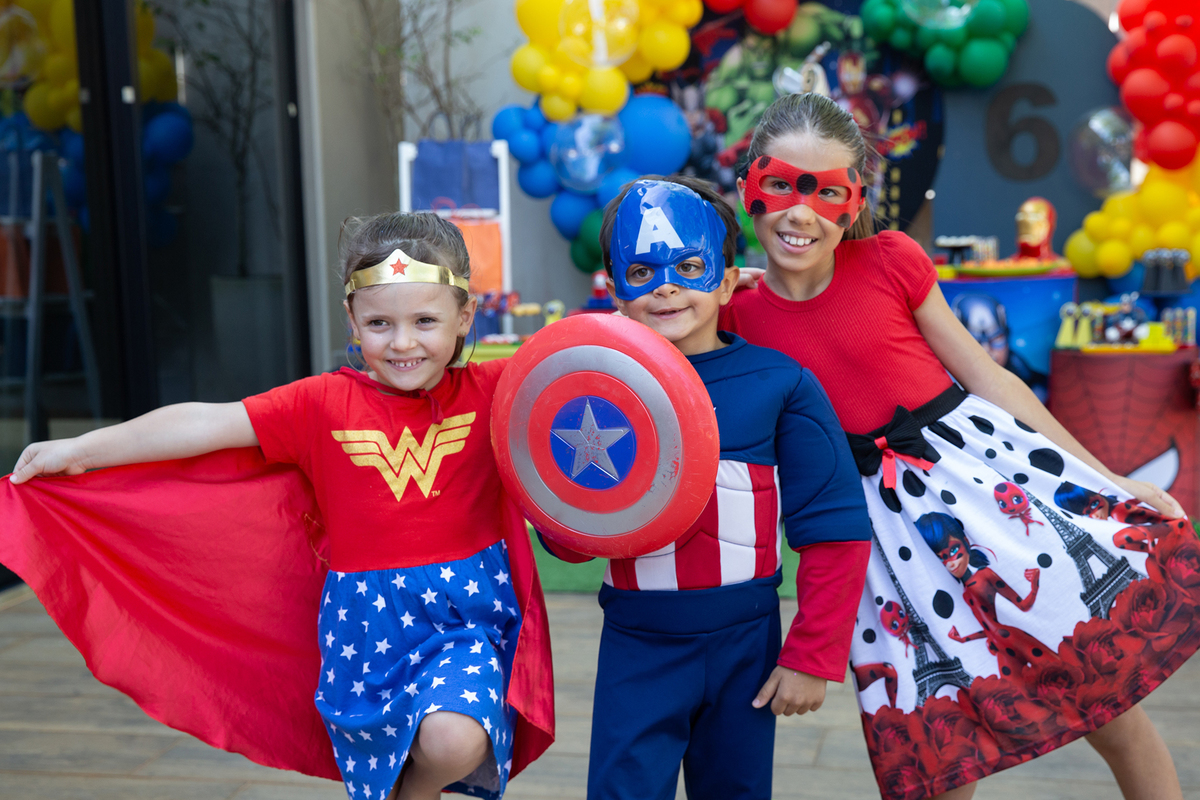 aniversariante e amiguinhas, fantasiados, posando em frente a decoração do aniversario 