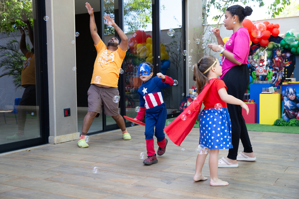 Momento de brincadeira entre crianças em festa infantil dos super heróis