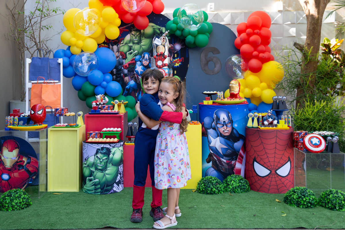 aniversariante e amiguinhas, fantasiados, posando em frente a decoração do aniversario 